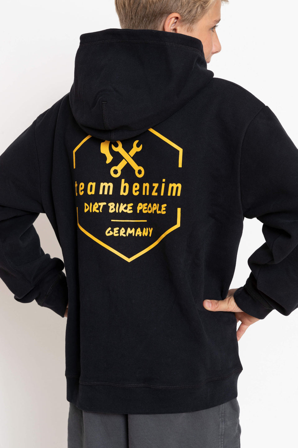 Kinder Hoodie Farbe schwarz mit gelbem Logo an Kindermodel Rückseite